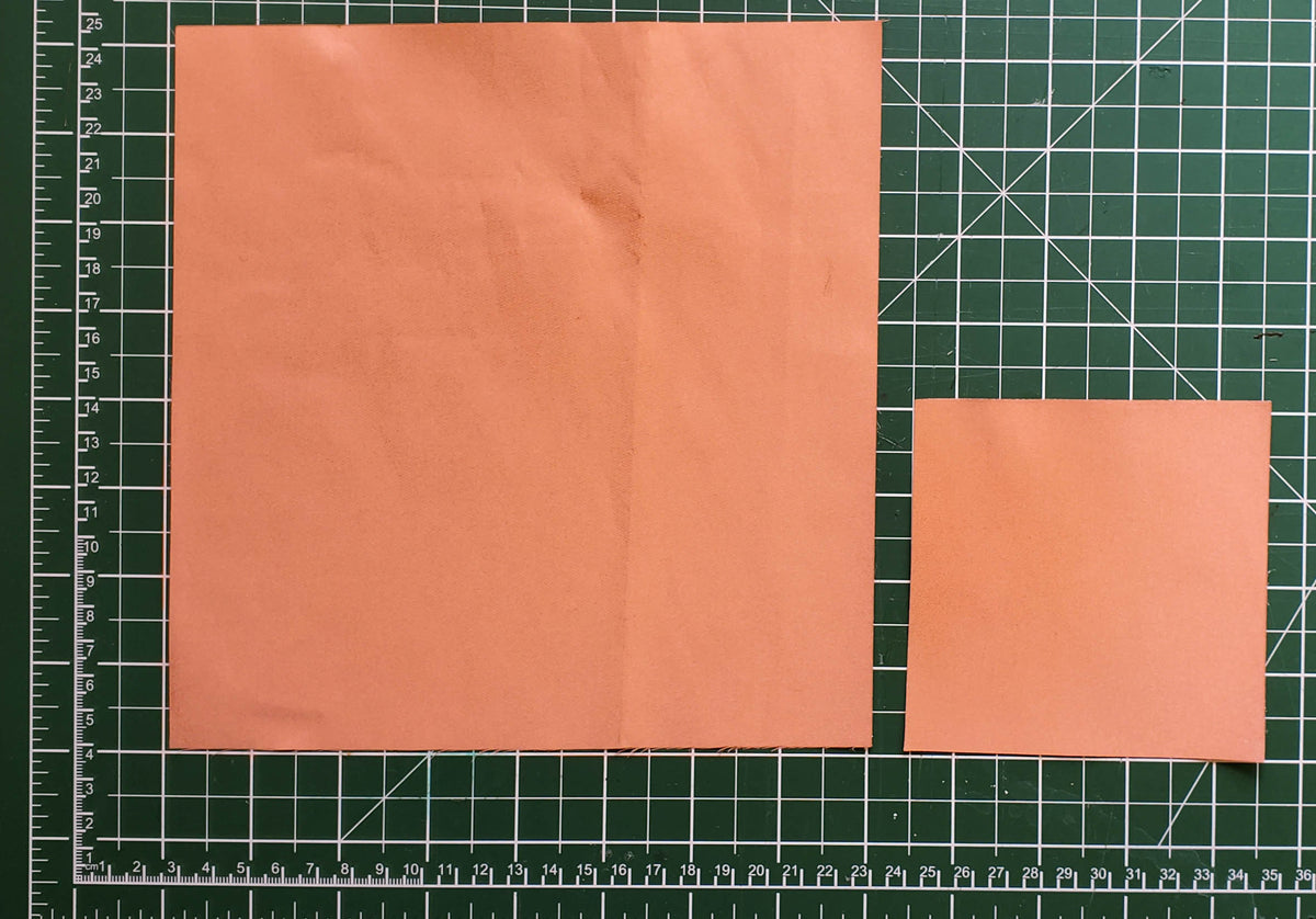 Large and small pieces of copper conductive fabric on a cutting mat