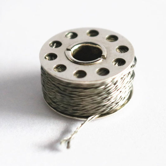 Close-up of a stainless steel 2-ply conductive thread bobbin