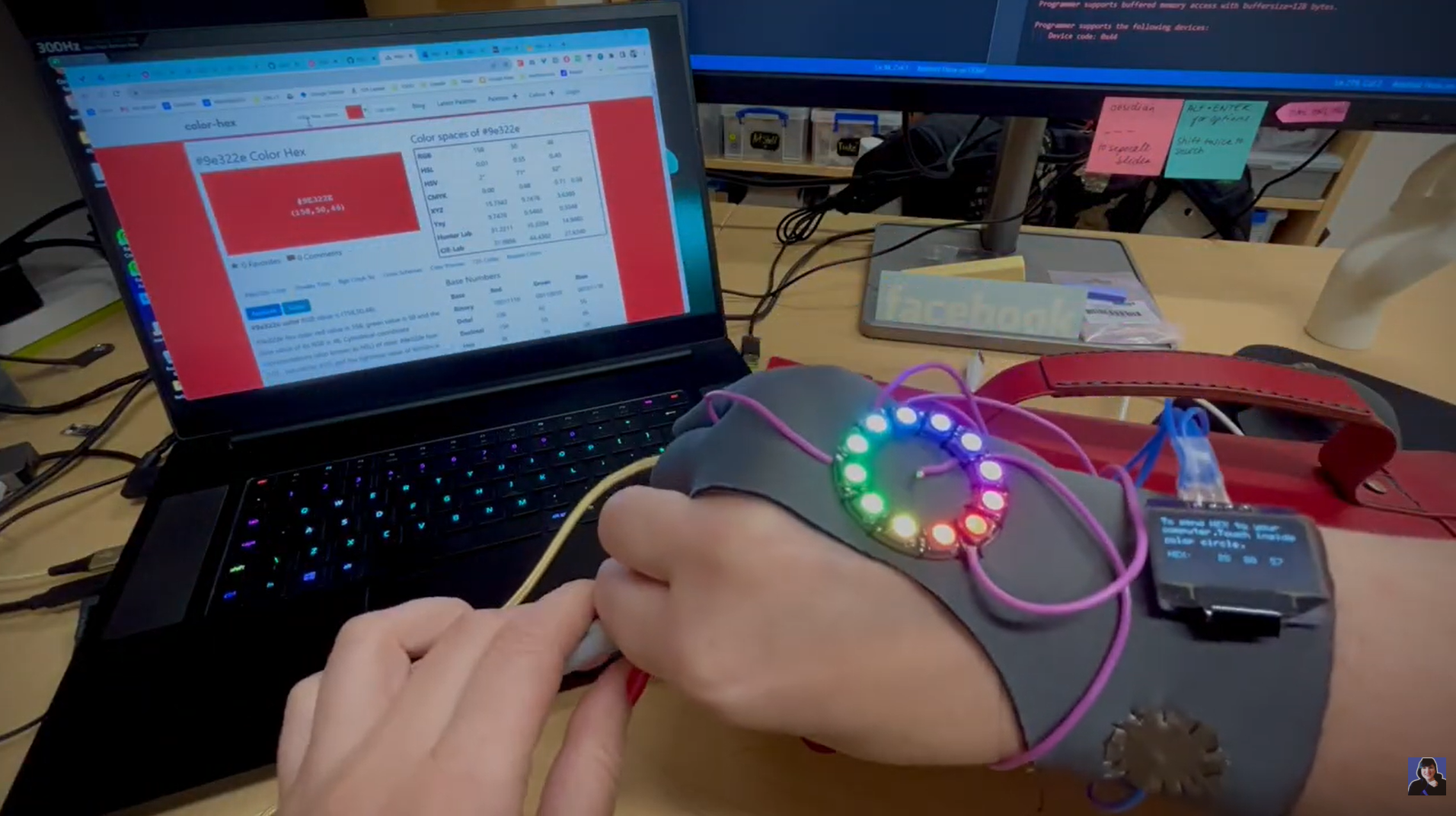 Person wearing a wristband with LED lights on a desk with a computer in the background