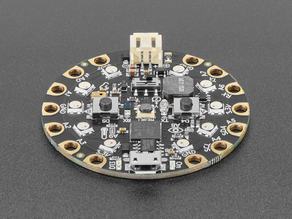 Round electronic circuit board with various components on a gray background