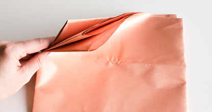 Close-up of fingers bending copper conductive fabric