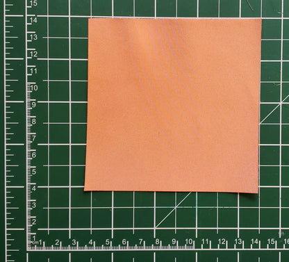 Square of copper conductive fabric on a green cutting mat